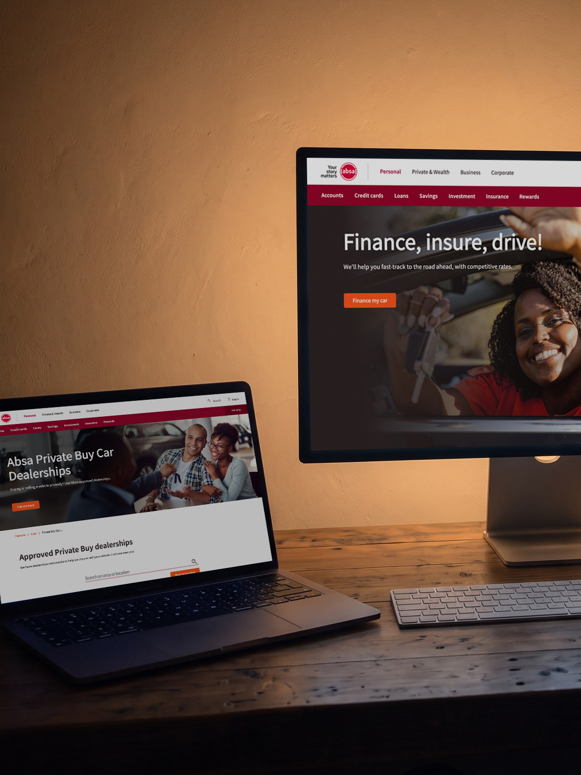 A designer’s desk at night lit by its screens: a large display showing Absa’s vehicle finance page headed Finance, insure, drive!, and beside it a laptop showing the Absa Private Buy Car Dealerships page, the same page shape holding two different products.