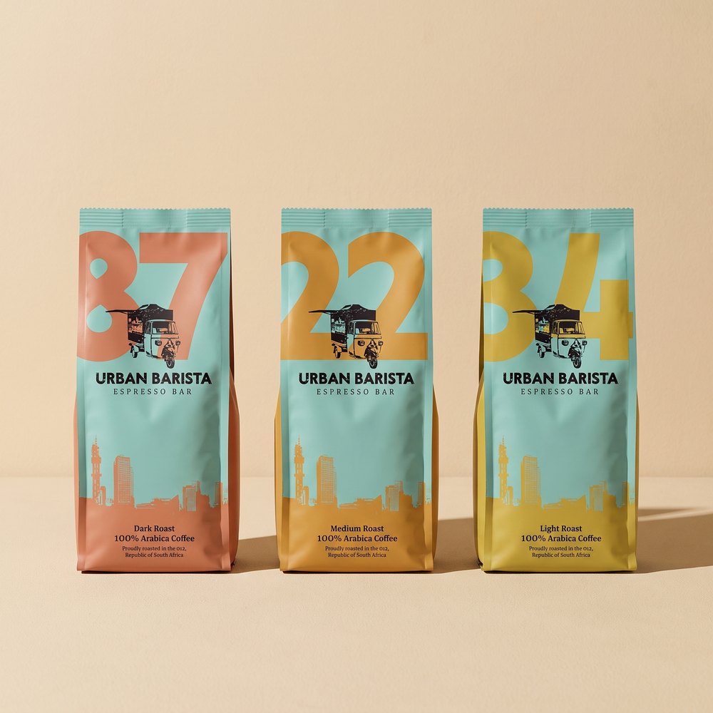 The three Urban Barista bag fronts side by side in teal with coral, ochre and mustard numerals.